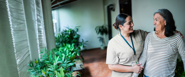 Hauspflegerin spricht mit einer Seniorin im Pflegeheim